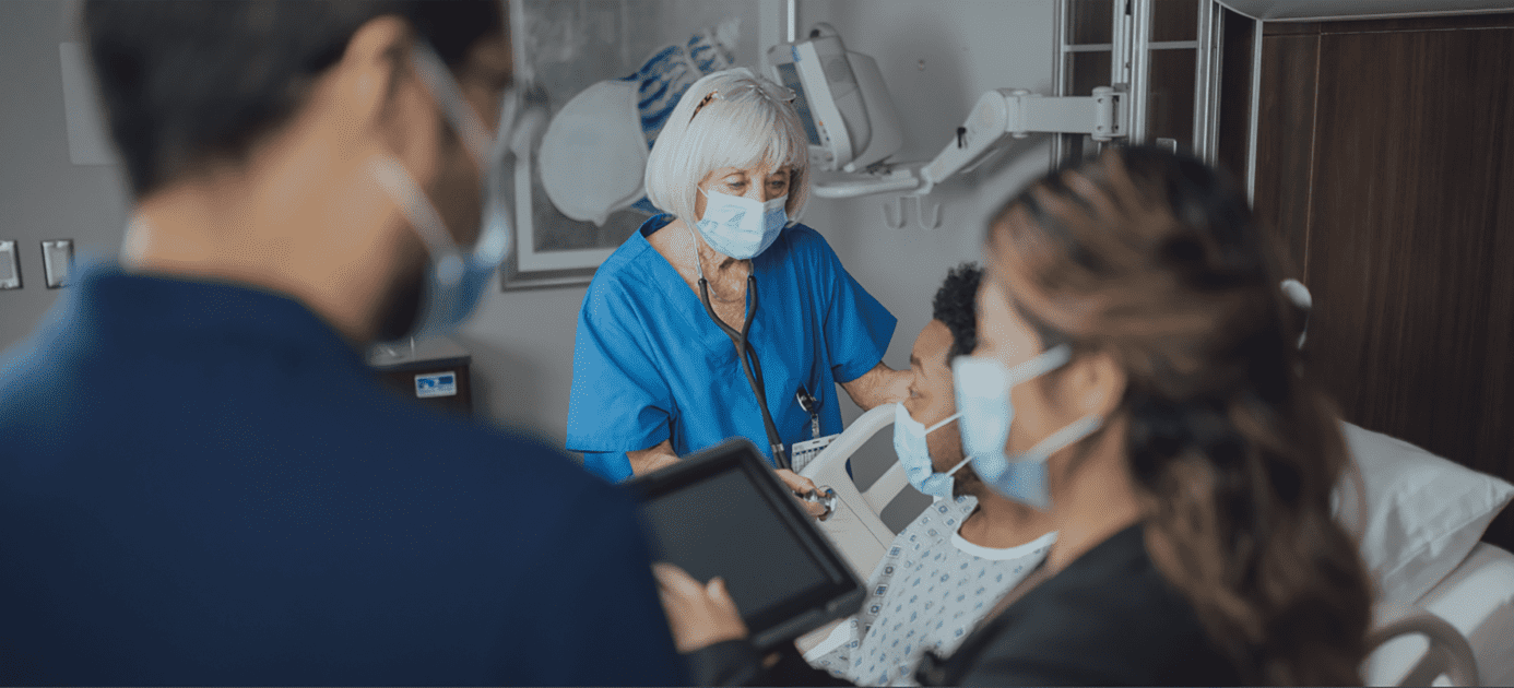 Elderly female patient discussing health records with medical staff in hospital room